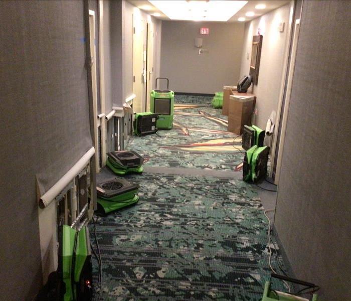 Photo of drying equipment drying a hallway following water damage